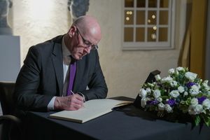 수석장관 존 스위니가 스코틀랜드 의회에서 샐먼드를 위한 조문록에 서명하는 모습, 10월 15일