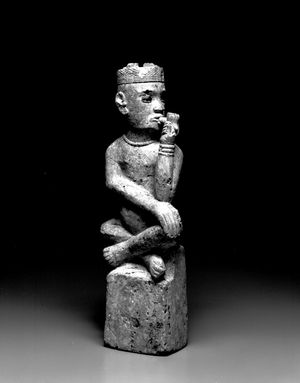 콩고(보마 아그룹). 19세기 무덤 표지(툼바(Tumba)). 콩고인들은 권력자의 무덤에 “툼바(tumba)”라고 불리는 돌 조각상을 놓았다. 그의 모자(mpu)에 달린 네 개의 표범 이빨, 구슬 목걸이, 팔찌(nlunga)는 그가 족장임을 나타낸다. “툼바”라는 용어는 포르투갈어의 오래된 “무덤”이라는 뜻의 단어에서 유래했으며, 이 유형은 콩고 묘지에 있는 유럽 상인과 선교사들의 무덤 기념물에서 영감을 받았을 수 있다. 브루클린 박물관