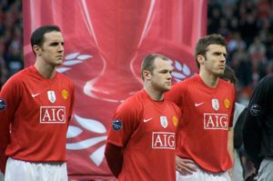 2009년 UEFA 챔피언스리그와 FIFA 클럽 월드컵 우승 배지를 착용한 오셰이, 웨인 루니, 마이클 캐릭 (맨체스터 유나이티드)