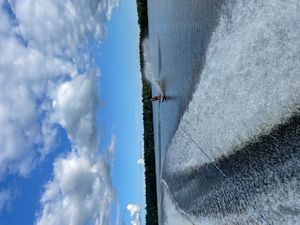 한 개의 스키(슬라럼 스타일)로 수상스키를 하는 젊은 남성