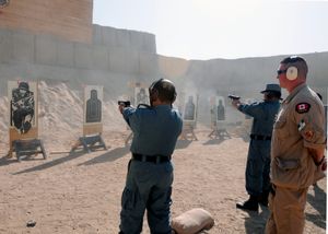 2010년 칸다하르에서 표적 사격 훈련 중인 아프가니스탄 국가경찰 대원들을 지켜보는 RCMP 경찰관 겸 교관