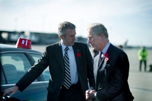 2009년, 근접 경호반 대원이 찰스 왕세자(현재 찰스 3세)의 차 문을 열어주고 있다.