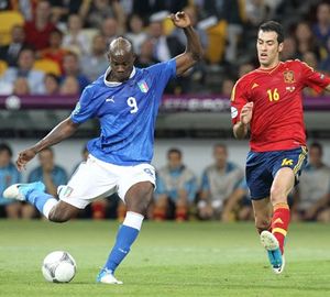 스페인 국가대표팀의 수비형 미드필더 세르히오 부스케츠(16번, 붉은색 유니폼)가 이탈리아 공격수 마리오 발로텔리의 슈팅을 막으려 한다.