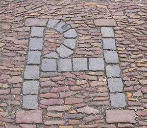 패트릭 해밀턴의 이니셜. 그의 순교를 기념하기 위해 처형 장소의 포장 도로에 새겨져 있다.