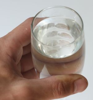 손에 든 물컵 안쪽에서 보이는 지문.