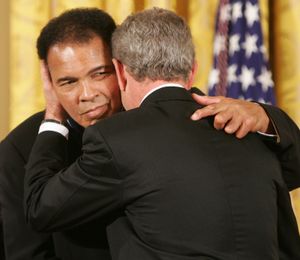 조지 W. 부시 대통령이 2005년 백악관에서 알리에게 대통령 자유 훈장을 수여한 후 포옹하고 있다.