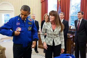 승무원들이 오바마 대통령에게 마지막 임무의 NASA 비행 점퍼를 선물하고 있다.