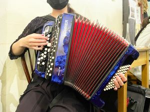 오른손이 3열뿐인 소형 크로마틱 아코디언을 연주하는 여성(도쿄)