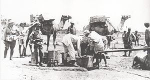 세 명의 병사들이 이집트 노동자들이 파이프에서 물통에 물을 채우는 것을 지켜보고 있다