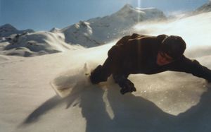 깊은 파우더 속에서 회전하는 스노보더가 원심력을 상쇄하기 위해 몸을 기울이는 모습
