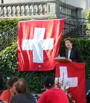 2007년 8월 1일 스위스 국경일에 연설하는 전 연방 의원 엘리자베트 코프. 여기서 보이는 연방기는 규정에서 권장하는 것보다 여백이 좁고, 십자가와 깃발 너비의 비율이 권장 비율인 5:8 대신 약 5:7이다.