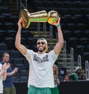 테이텀이 퍼레이드에서 래리 오브라이언 챔피언십 트로피를 들고 있는 모습.