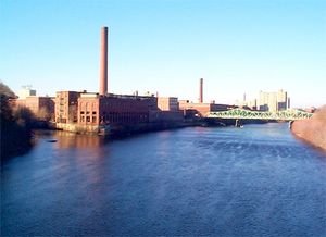 메리맥 강과 콩코드 강이 합류하는 지점의 매사추세츠 공장; 콕스 다리 건너편에는 부트 공장이 있으며, 왼쪽 위에는 상징적인 간판이 있는 역사적인 로웰 선 건물이 있다.