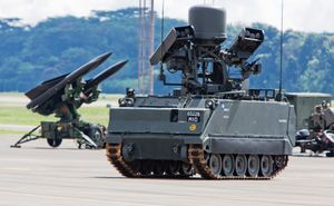 배치된 M-113A2 초기계화 이글라 IFU 시범, 배경에는 I-HAWK SAM 발사대가 보임