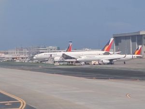 필리핀 항공 항공기가 루프트한자 테크닉 필리핀의 정비 격납고 옆에 주차되어 있다.