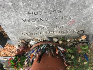 펜, 연필, 깃털, 화분에 심은 식물이 마르그리트 뒤라스의 무덤 주변에 놓여 있다