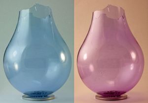 네오디뮴 유리 전구. 바닥과 내부 코팅을 제거한 상태로 형광등과 백열등 두 가지 조명 아래에서 촬영되었다.