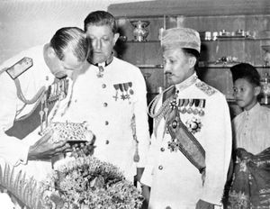 1959년, 에든버러 공작(왼쪽)이 이스타나 다룰 하나에서 브루나이에서 제작된 은색 담뱃갑을 감상하고 있다