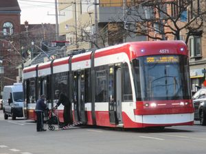 노약자의 저상 전차 승차를 돕고 있는 전차 운전사