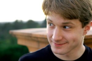 볼에 보조개가 있는 남자가 미소짓고 있다