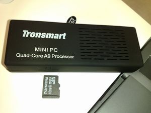 Tronsmart MK908, 록칩 기반 쿼드 코어 안드로이드 "미니 PC". 크기 비교를 위해 microSD 카드가 옆에 있다.