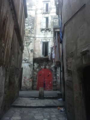 구시가지의 비아 카바. 옛날 여러 층짜리 궁전의 빨간색 아치형 문은 2013년부터 구시가지의 특징이 된 거리 예술의 한 예이다