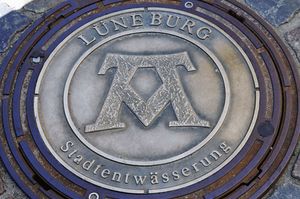 “Mons, Pons, Fons” (산, 다리, 샘)을 보여주는 맨홀 뚜껑