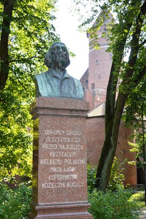 배경에 니콜라우스 코페르니쿠스의 올슈틴 성이 있는 흉상