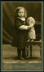 인형을 들고 있는 독일 소녀. 전통적으로 여성스러운 장난감이다. (20세기 초 헤르만 카프스(Hermann Kapps)의 사진)