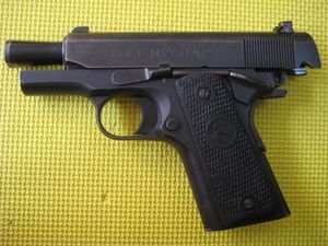 슬라이드가 뒤로 빠져 벌집 배럴이 드러난 콜트 M1911A1 콤팩트 ORM 권총