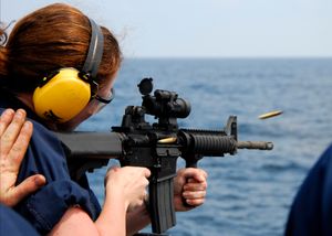 미 해군 병사가 구축함 벨라 걸프(CG-72) 함미에서 M4 카빈 소총을 발사하는 모습