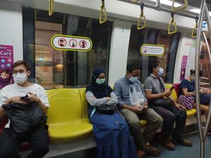 마스크를 쓴 승객들과 기차에서 이야기하지 말라는 안내 표지판