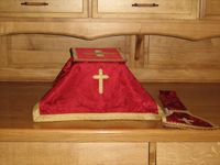 서양식 성작 보와 성배 보가 성물 위에 놓여 있다. 성배 오른쪽에는 제의인 수건(maniple)이 놓여 있다.