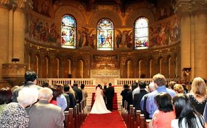 교회에서 기독교 목사가 신랑과 신부(신부는 면사포를 쓰고 있음)의 결혼식을 집례하고 있다.