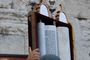 한 남자가 예루살렘 서쪽 성벽(Western Wall)에서 세파르디 유대인(Sephardi Jews) 스타일의 토라를 들고 있다