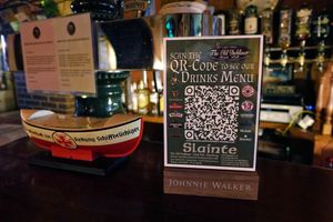 음료 메뉴로 연결되는 QR 코드가 있는 표지판