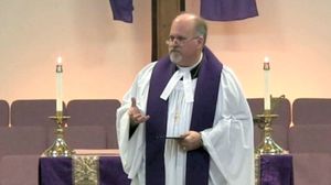 감리교 목사가 수단, 흰옷과 영대를 착용하고 칼라에 설교 밴드를 부착한 모습. 감독제 교단의 목사 복장을 보여준다.