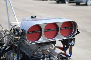 과급 드래그 레이싱 차량의 연료 분사 플레넘 위에 있는 트리플 버터플라이 스로틀 보디