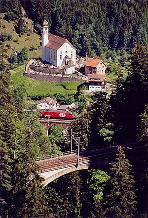 수스텐 고개로 가는 길에서 본 SBB Re 460 (중앙), 바센 교회 (배경), 그리고 고트하르트 철도의 상부 및 중부 마이엔로이스 다리 (아래).