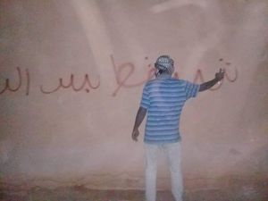 수단인이 벽에 혁명 구호를 뿌리고 있다.