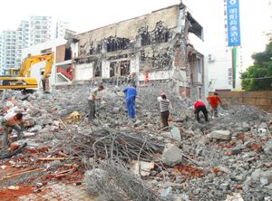 중국의 건물 철거 현장에서 철거 잔해에서 철근을 추출하는 작업자