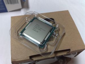 인텔 하스웰 i7-4771 CPU, OEM 팬 냉각 방열판이 들어 있는 정품 포장 위에 놓여 있음