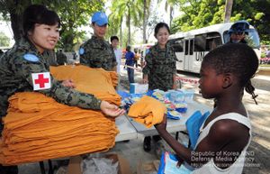 단비부대 장병들이 레오간시 희망프로젝트의 일환으로 아이티 아이들에게 티셔츠를 나눠주고 있다.