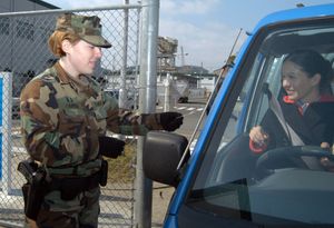 군사 경찰이 운전자가 군사 기지에 들어갈 수 있도록 허용하기 전에 신분증을 확인하고 있다.