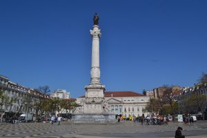 월계관과 군복을 입고 서류 뭉치를 들고 있는 남자가 새겨진 흰색 돌기둥의 사진