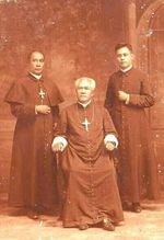 날짜 미상의 아글리파이(가운데, 앉아 있음), 두 명의 IFI 사제와 함께