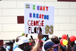 시위자가 "#숨을 쉴 수 없다 조지 플로이드 '93"이라고 적힌 표지판을 들고 있다