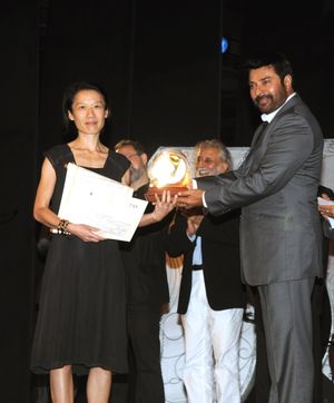 배우 겸 감독 맘무티가 르콩트에게 영화 여행자(A Brand New Life)로 최우수 감독상을 수여하고 있다.