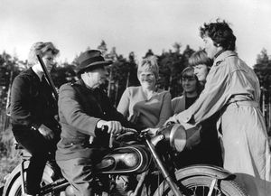 1959년 9월 동독 노이슈트렐리츠 근처에서, 산림 관리인(오토바이 탑승)이 한 교대 근무 동안 16,000 그루의 할당량에 25,000 그루의 묘목을 심어 생산 목표의 184%를 달성한 여성 팀을 축하하고 있다.