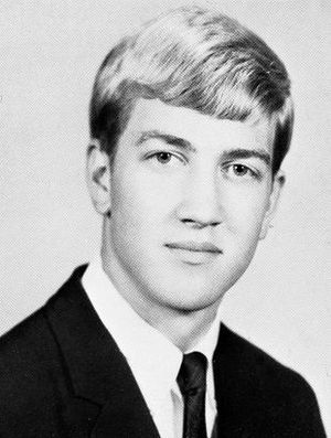 1964 high school senior photo portrait of Lynch in a suit